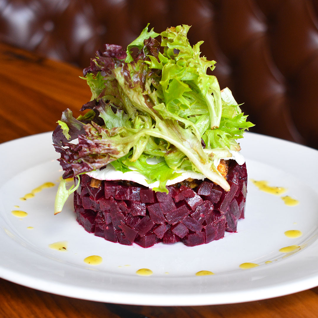 Roasted Beet Tower with marinated beets, goat cheese, candied walnuts, roasted onions, mixed field greens, mustard vinaigrette.