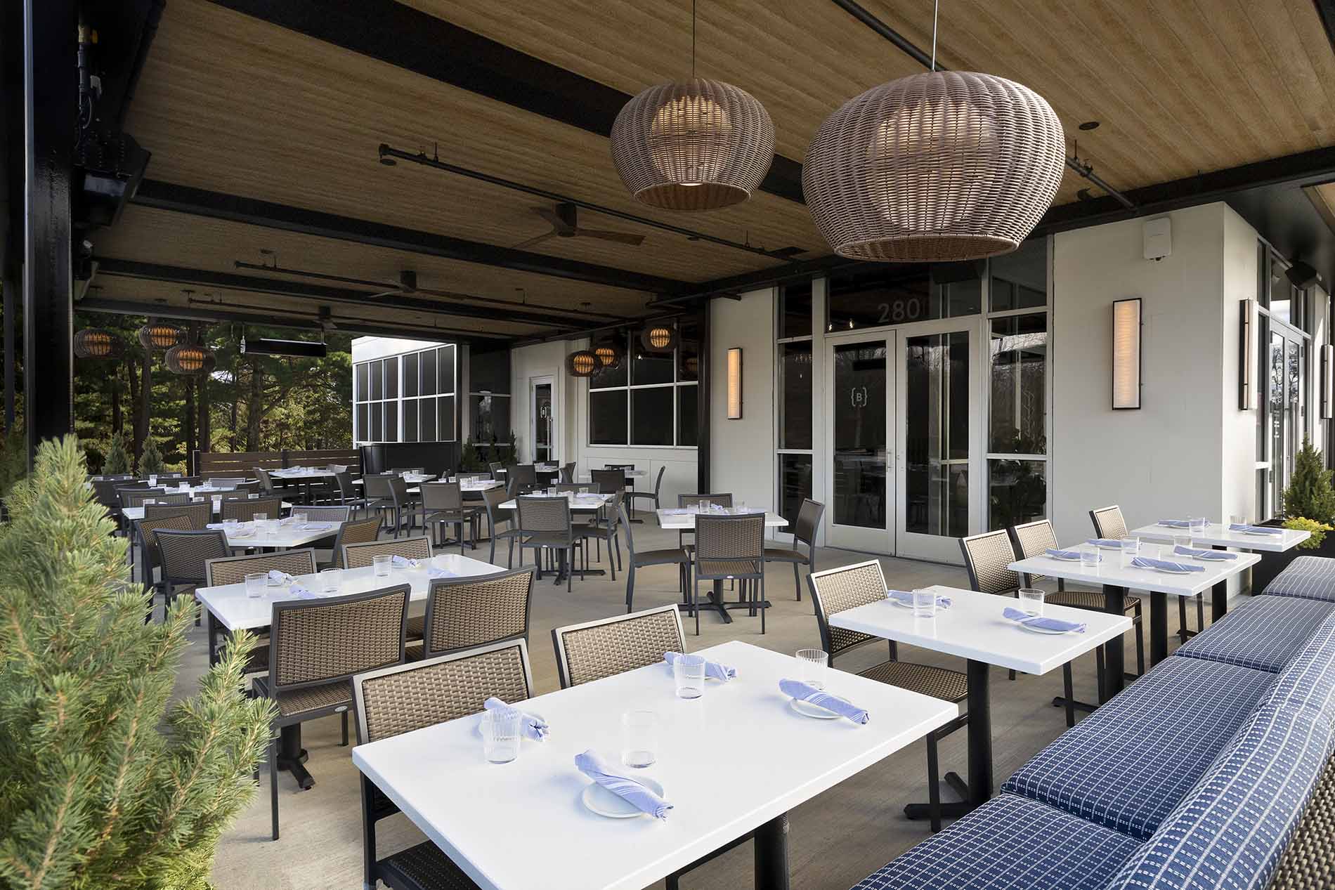 Spacious outdoor seating at Burtons Grill & Bar with elegant tables, casual ambiance, perfect for dining and drinks.
